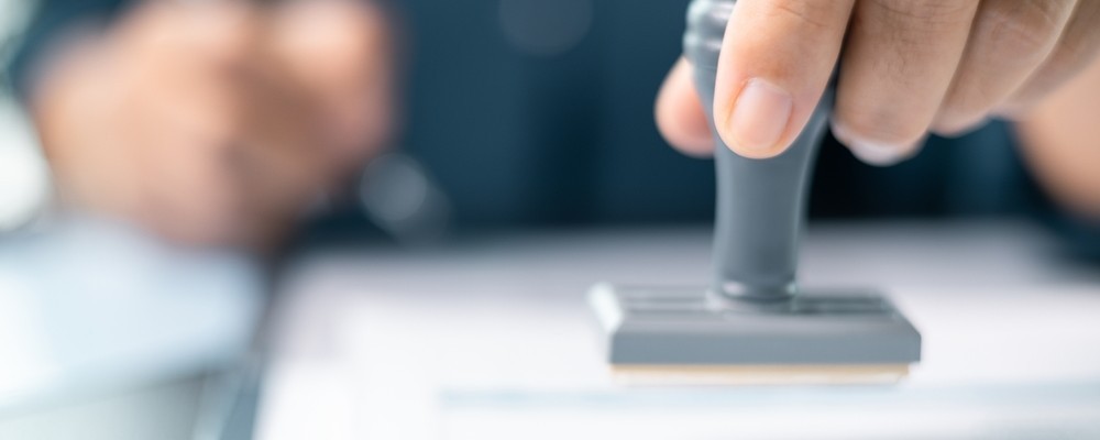 Banking officer stamped the document to approve the loan, finalizing contract and solidifying the finance agreement
