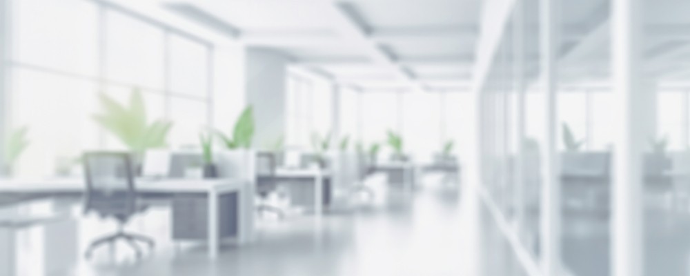 Blurred image of an empty office space with chairs and monitors