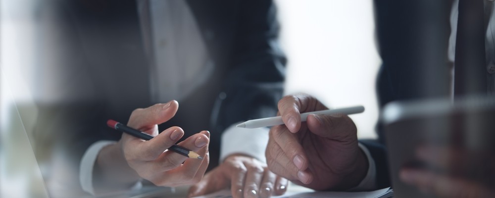 Two people in business discussing a document