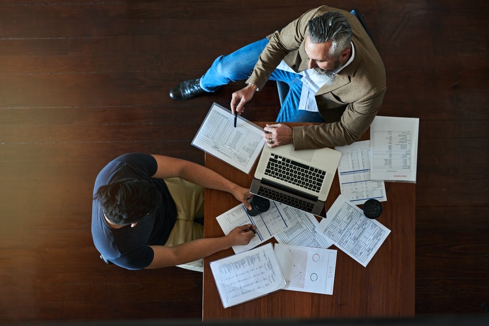 People reviewing physical and computer documents