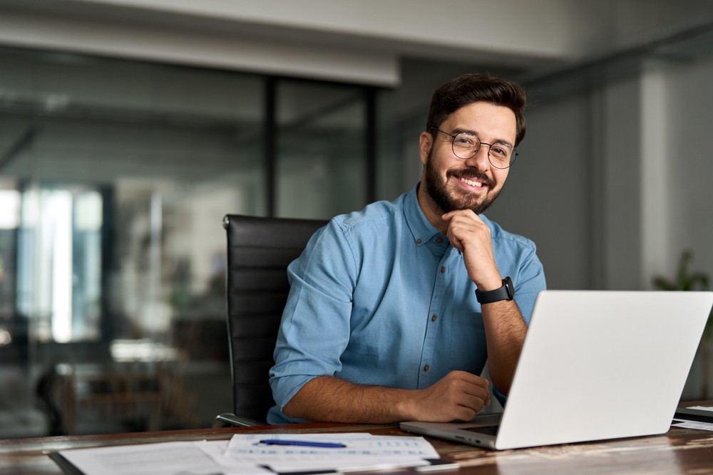 People looking at the camera in business clothing with a laptop