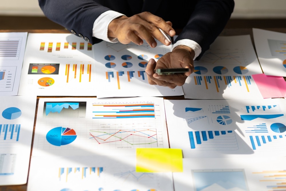 Person looking over multiples documents at a desk. 