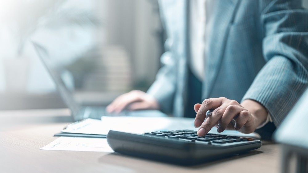 Business person using a calculator at a desk