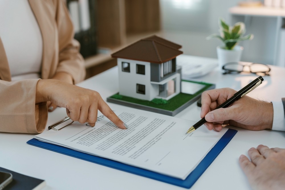 A document on a desk with a model house