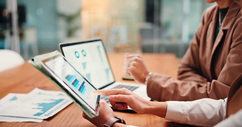 Two people looking over online graphs and documents