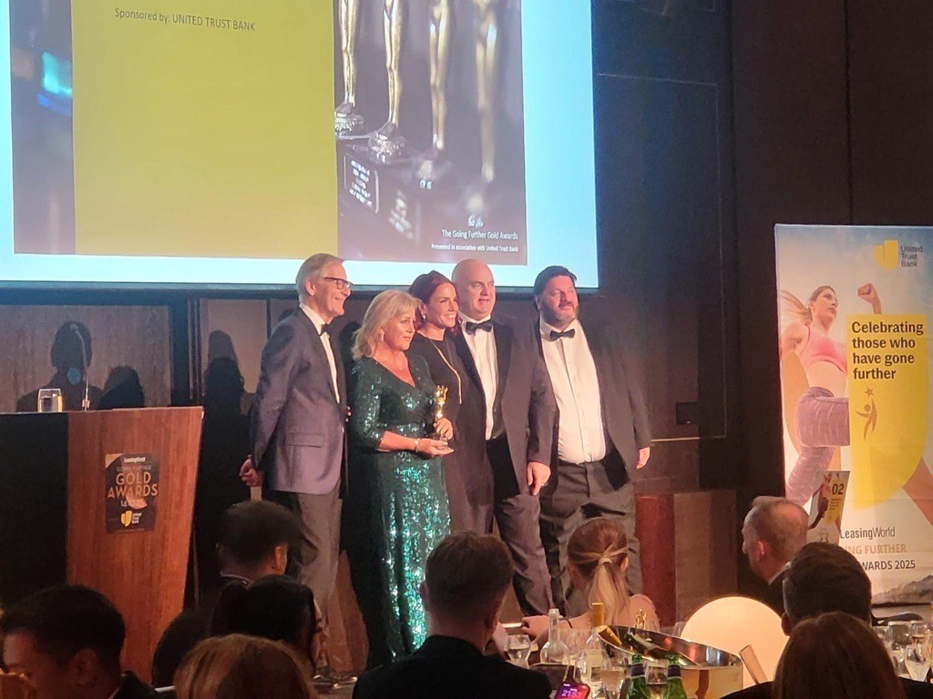 Sue Chapman, Dave Chapman, and Gary Burns collecting an award