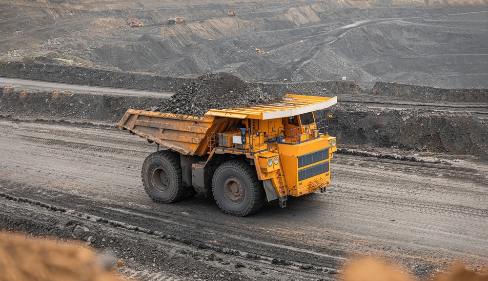 A dump truck driving on a gravel road in a quarry