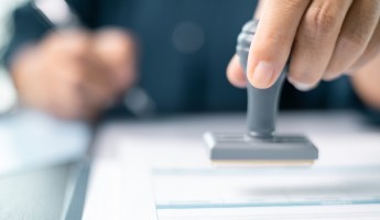 Banking officer stamped the document to approve the loan, finalizing contract and solidifying the finance agreement