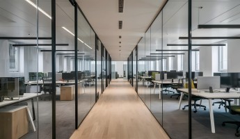 Modern office interior showing desks, monitors, and chairs