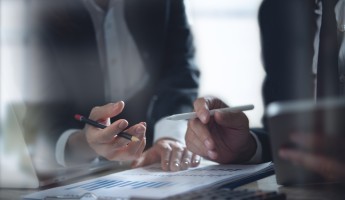 Two people in business discussing a document
