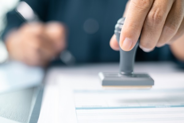 Banking officer stamped the document to approve the loan, finalizing contract and solidifying the finance agreement