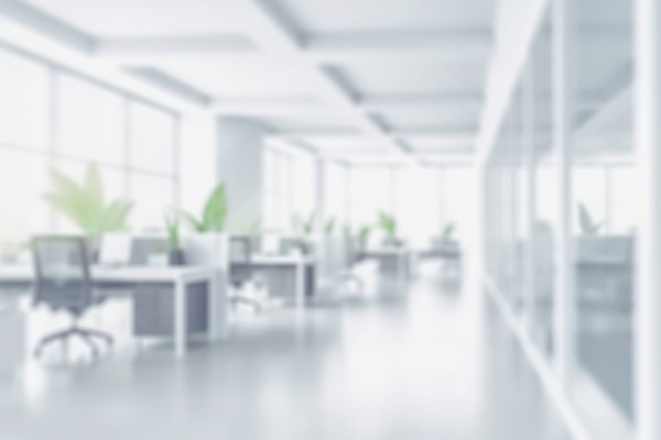 Blurred image of an empty office space with chairs and monitors