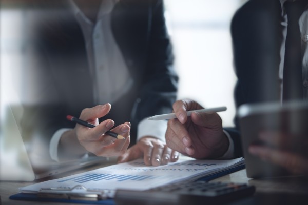 Two people in business discussing a document