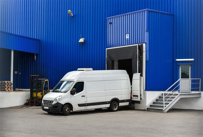 Van in loading and unloading commercial cargo in warehouse dock