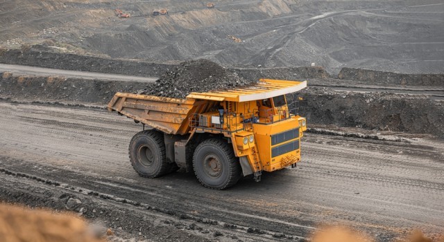A dump truck driving on a gravel road in a quarry