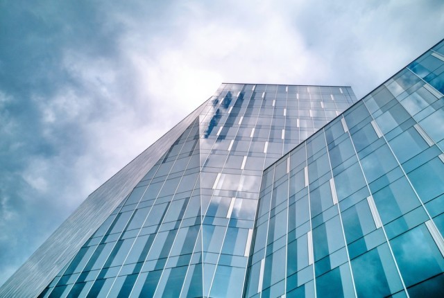 A skyscraper with clouds up in the sky