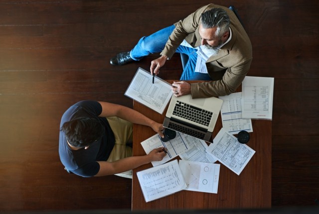 People reviewing physical and computer documents