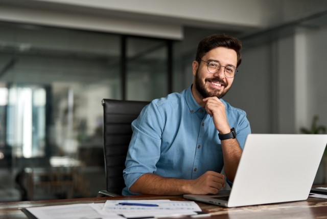People looking at the camera in business clothing with a laptop