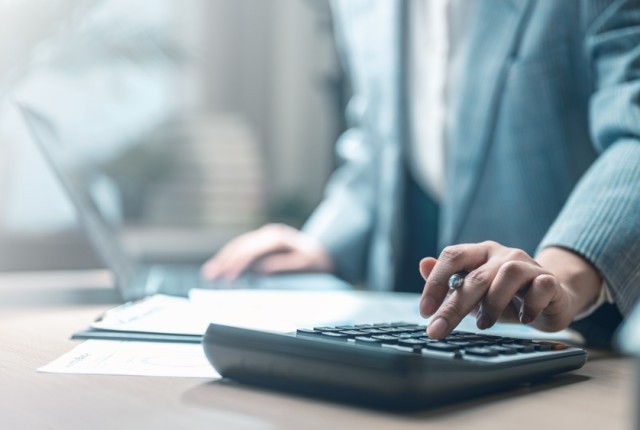 Business person using a calculator at a desk