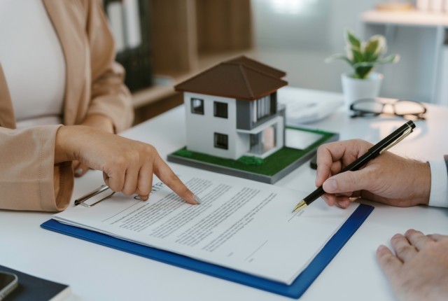 A document on a desk with a model house