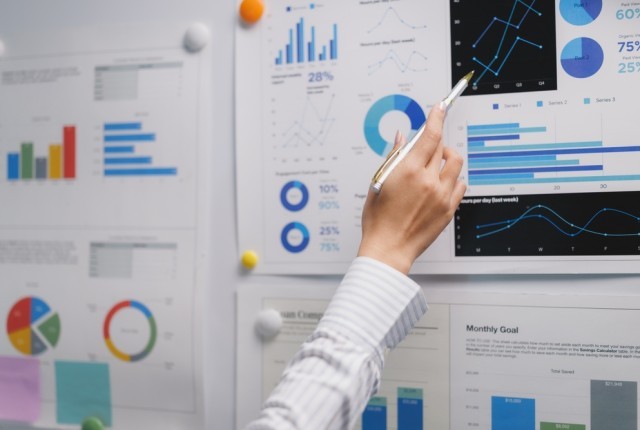 Person looking over multiple graphs and charts