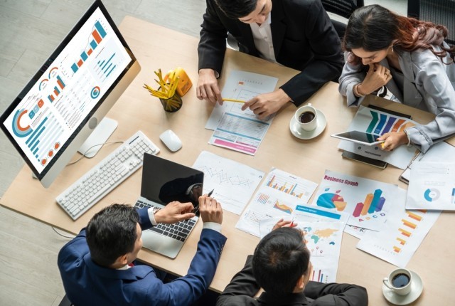 A group of business people discussing information on documents
