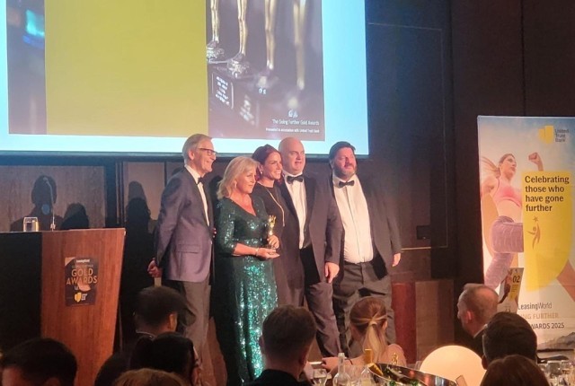 Sue Chapman, Dave Chapman, and Gary Burns collecting an award