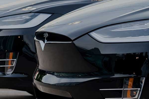 A Tesla in a line of cars
