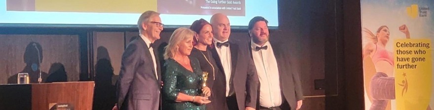 Sue Chapman, Dave Chapman, and Gary Burns collecting an award
