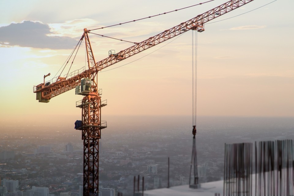 A crane working on a skyscraper building